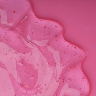 Top view of face serum in a pink background